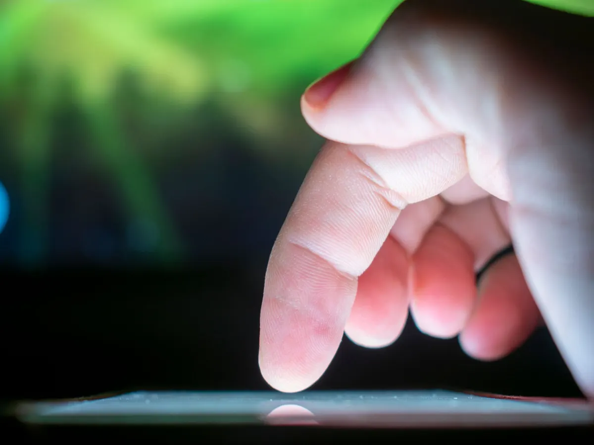 Ein Finger tippt auf einen Touchscreen